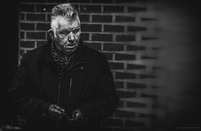 Man looking away against wall