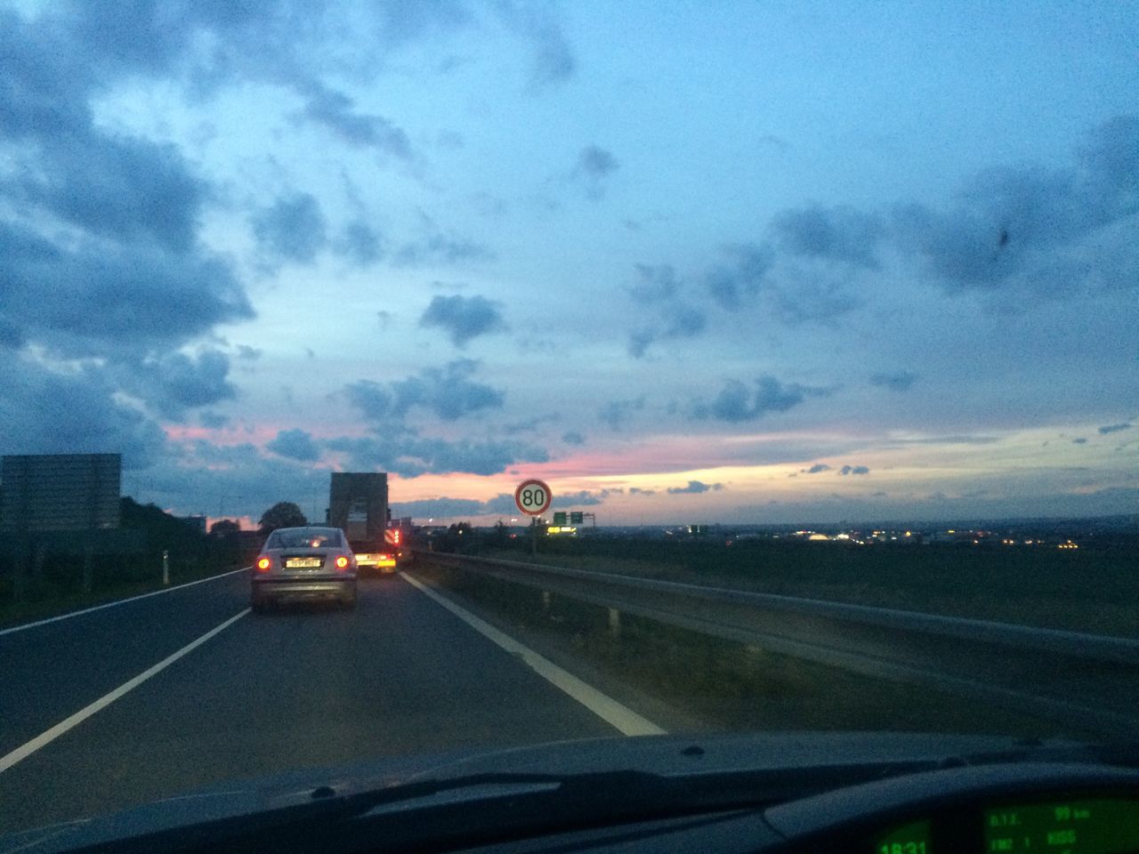 vehicle interior, car, cloud - sky, road, transportation, car interior, glass - material, windshield, sky, land vehicle, the way forward, car point of view, no people, mode of transport, sunset, day, nature, illuminated, storm cloud, outdoors