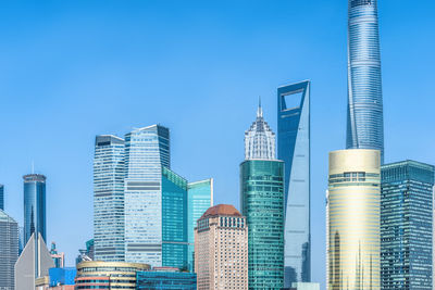 Low angle view of modern buildings against clear blue sky