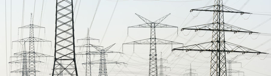 Panoramic view of electricity pylons against clear sky