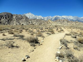 Scenic view of desert against clear blue sky