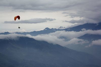 Low angle view of person paragliding against sky