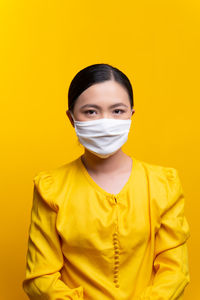 Portrait of mid adult man against yellow background