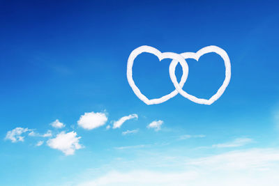 Low angle view of heart shape against blue sky