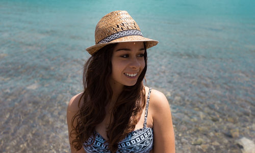 Portrait of young woman standing at beach