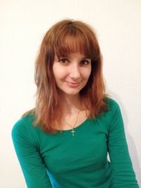 Portrait of smiling young woman against white background