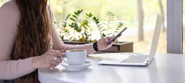 Close-up of woman using mobile phone at home