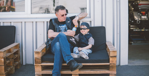 Full length of a young man sitting outdoors