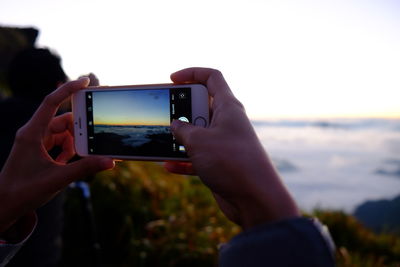 Cropped image of hand holding mobile phone