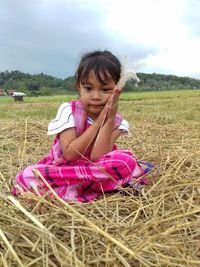 Cute girl sitting on field