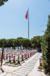 Red flag on cemetery against sky
