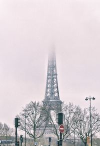 Low angle view of communications tower in city