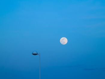 Low angle view of moon against blue sky