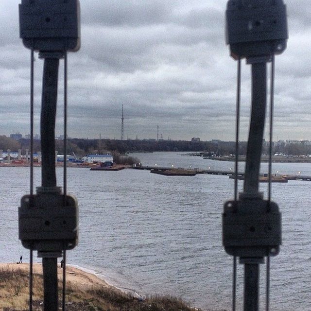 water, street light, sky, pole, metal, lighting equipment, sea, cloud - sky, tranquility, safety, river, outdoors, no people, nature, weather, day, guidance, protection, close-up, focus on foreground