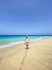 Scenic view of beach against clear blue sky