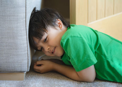 Portrait of boy lying on bed at home