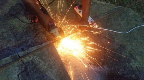 Low angle view of hand holding firework display