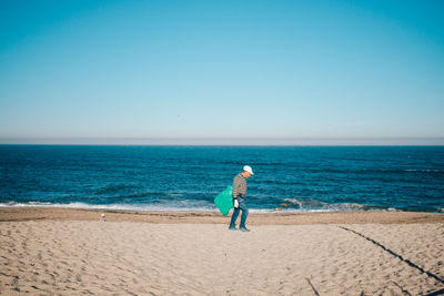 Rear view of man walking on beach