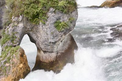 Scenic view of rock formation by river against sky