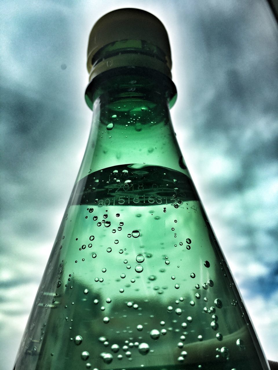 cloud - sky, drop, bottle, sky, glass - material, low angle view, nature, water, no people, transparent, wet, container, close-up, focus on foreground, refreshment, water bottle, beer bottle, drink, outdoors, glass, rain, raindrop, purity