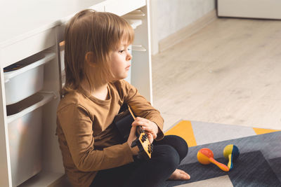 Child at home learning to play the guitar. leisure and education at home. 