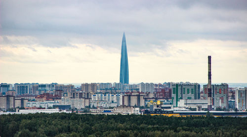 Buildings in city against cloudy sky