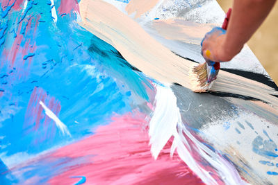 Drip painting expression art on canvas with blue, pink and beige colors, artist art performance