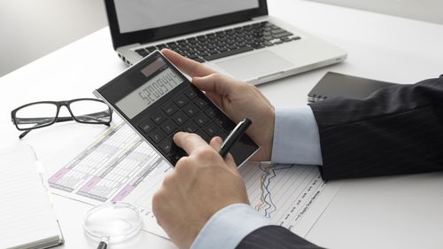 Cropped hands of businessman working on table