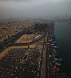 High angle view of illuminated city by buildings against sky