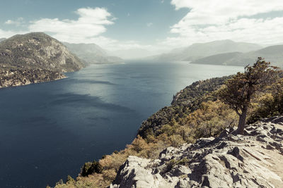 Scenic view of sea and mountains against sky