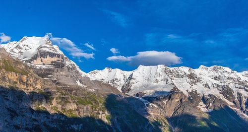 Scenic view of snowcapped mountains against blue sky