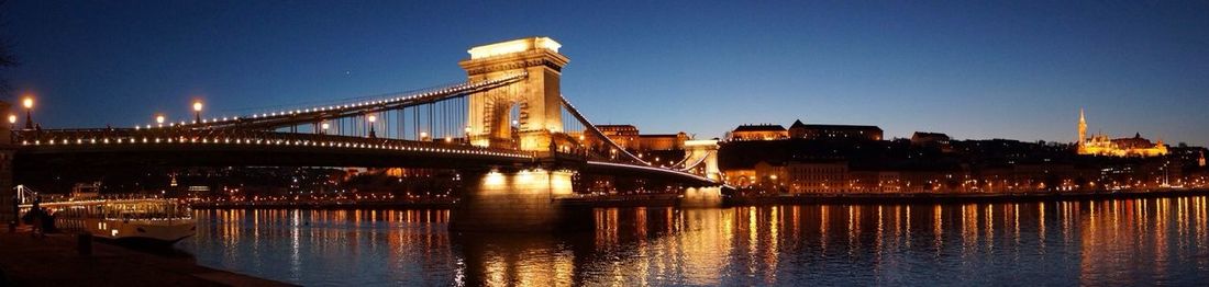 Suspension bridge over river at night