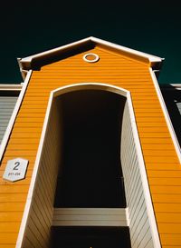 Low angle view of yellow building against sky