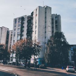 Road by buildings against sky in city