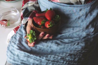 Midsection of woman holding strawberries