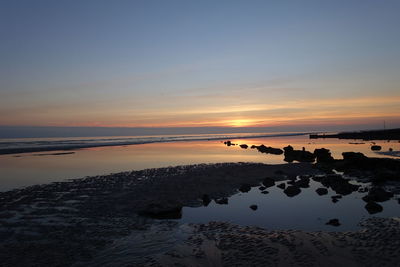 Scenic view of beach against sky during sunset