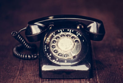 Close-up of rotary phone on wooden table