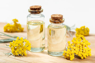 Close-up of yellow flowers in glass jar on table