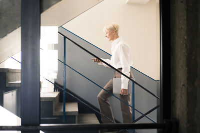 Side view of woman standing on staircase