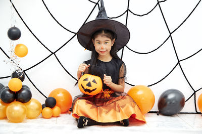 Low angle view of girl holding pumpkin