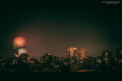 Illuminated cityscape against sky at night
