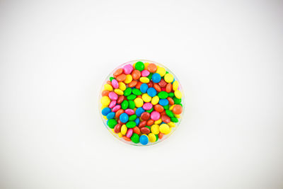Directly above shot of multi colored candies against white background