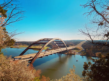 Bridge over river against clear blue sky