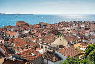 High angle view of townscape by sea against sky