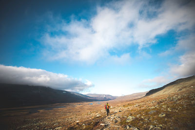 Man standing on mountain against sky