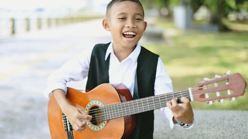 Portrait of boy playing guitar