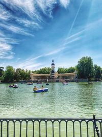 View of boats in river against cloudy sky