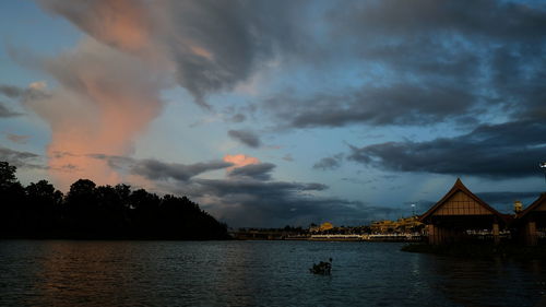 Panoramic view of lake and buildings against sky during sunset