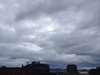 Low angle view of buildings against cloudy sky