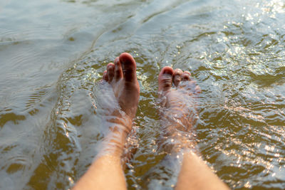 Low section of child legs in lake